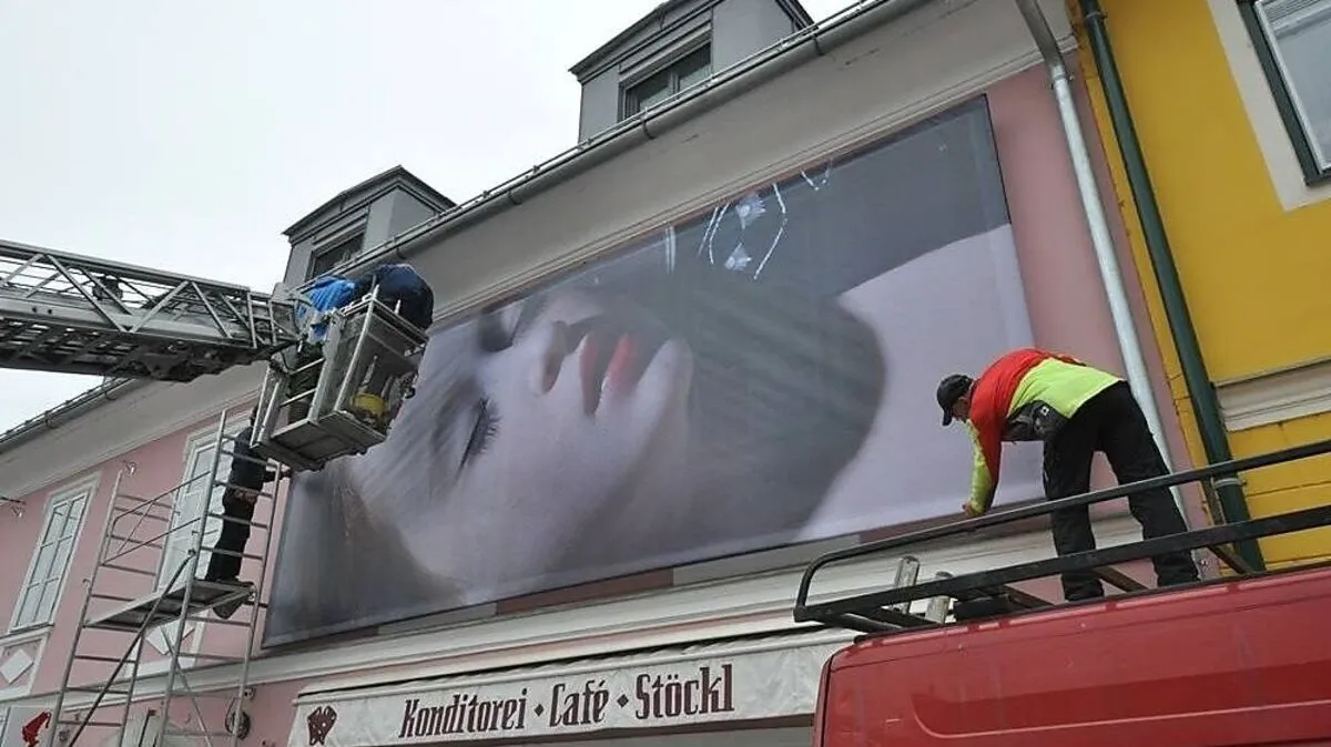 Zehn Häuserfassaden werden am Bleiburger Hauptplatz mit den Bildern des "Schockmalers" verhüllt