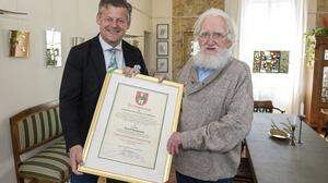 Bürgermeister Christian Scheider überreicht die Ehrenurkunde der Landeshauptstadt Klagenfurt an Arnulf Komposch