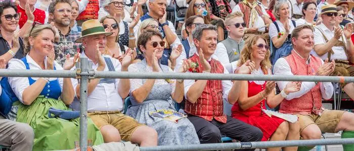 Eine Freilufttribüne mit vielen Menschen in Tracht