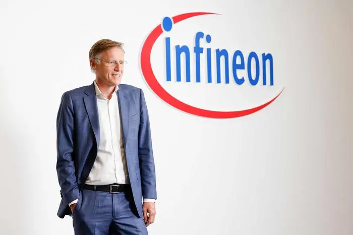 Jochen Hanebeck, CEO of Infineon Technologies, stands next to his company's logo as he arrives to address his company's annual press conference at Infineon's headquarters in Munich, southern Germany, on November 12, 2024. (Photo by Michaela STACHE / AFP)
