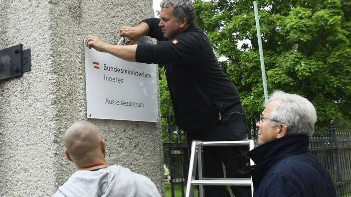 Der ehemalige Flüchtlingskoordinator Ferry Maier und ein Team der Plattform "Menschen.Würde.Österreich" haben am Donnerstag die "Ausreisezentrum"-Tafel bei der Erstaufnahmestelle für Asylwerber in Traiskirchen abmontiert