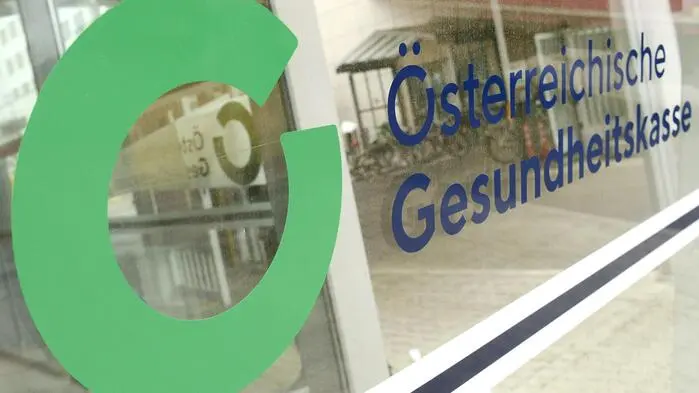 Das Bild zeigt das Logo der Österreichischen Gesundheitskasse auf einer Fensterscheibe