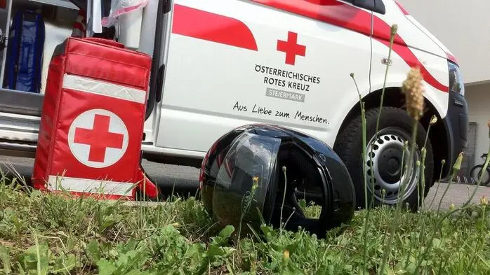 Ein Sturzhelm liegt auf dem Boden neben einem Rettungswagen