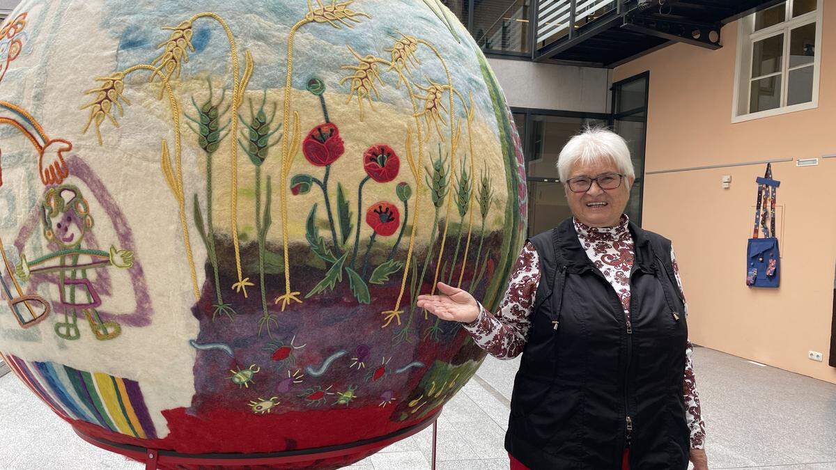 Künstlerin Hannelore Fasser im Brucker Rathaushof mit einer der drei Bälle ihrer Ausstellung, der für die Erde steht