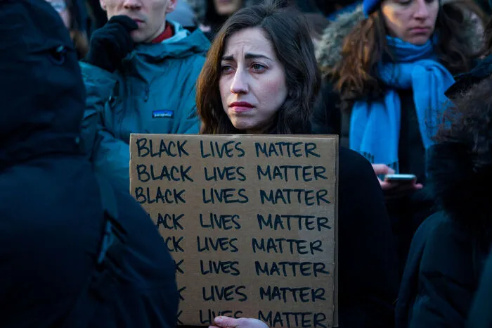 New York: Demonstranten hören sich Reden an und halten Schilder in die Höhe, um gegen die tödliche Schießerei von Shahed Vassell am Mittwoch zu protestieren.
