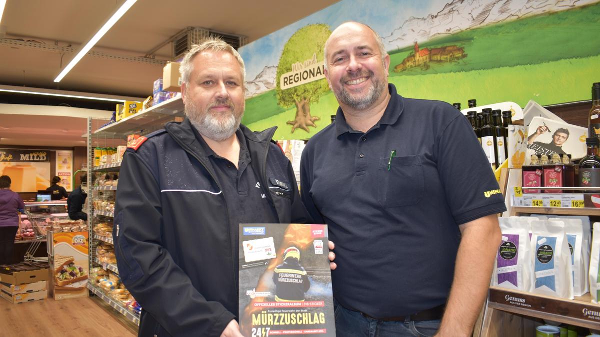 Kommandant-Stellvertreter Hans-Jürgen Sturm und Reinhard Kroiss von Unimarkt mit dem Stickeralbum