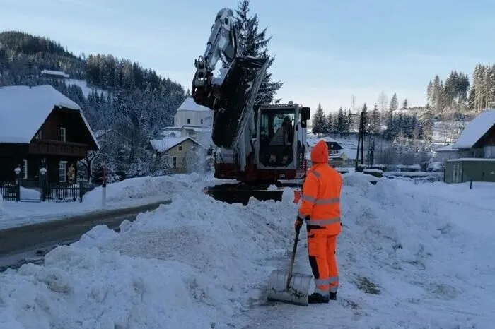 Mit Hilfe eines Baggers wird der Schnee am Pfaffensattel beiseite geräumt.