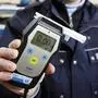  Polizei, Polizist mit Atemalkohol Testgerät. Zur Überprüfung der Fahrtüchtigkeit eines Autofahrers, zeigt 0,0 Promille Alkohol im Atem an. Polizei