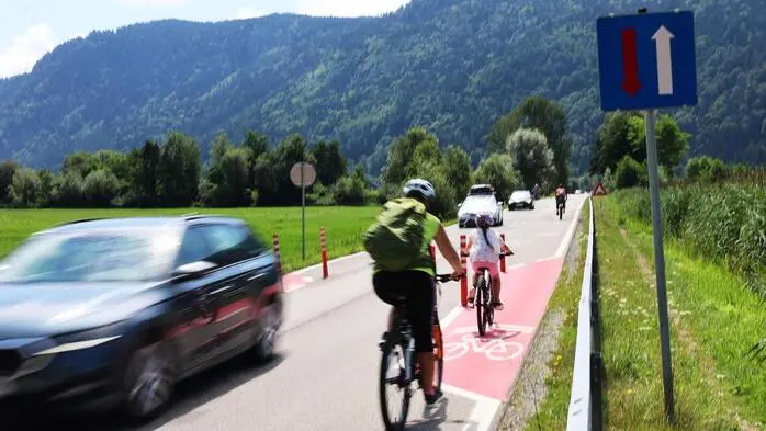 Im Bleistätter Moor am Ossiacher See sorgen Verengungen durch Poller und eine farbige Markierung für eine Verlangsamung des Verkehrs auf einer geraden Straße
