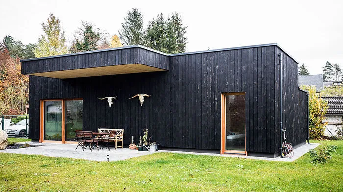 Die Fassade des schwarzen Hauses besteht aus Fichtenholz, dass nach der alten japanischen Technik „Shou Sugi Ban“ behandelt wurde. Dabei wird das Holz verbrannt und danach gebürstet.