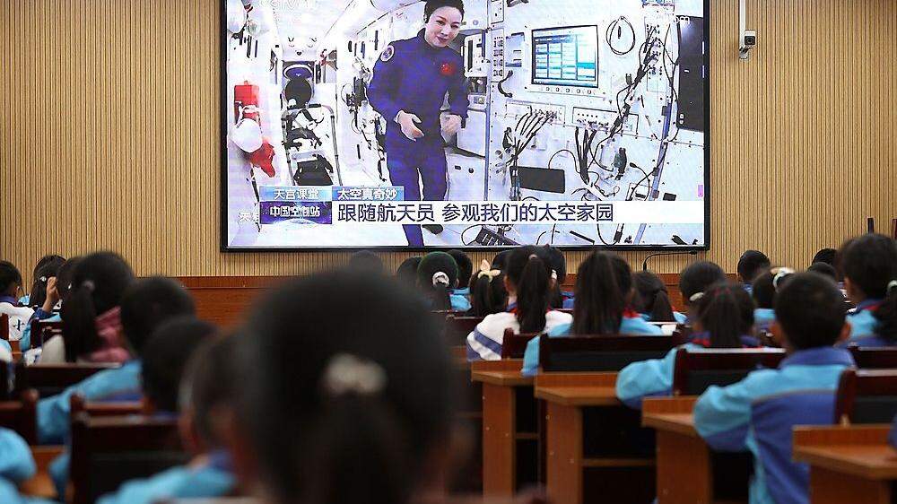 Ein weibliches Mitglied der aktuellen Besatzung der  &quot;Tiangong&quot; berichtet Schülern auf der Erde von ihrer Arbeit