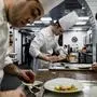 Cooks and waiters work in the kitchens of the Auberge de Collonges restaurant, in Collonges au Mont d’Or on January 26, 2024. The renovated inn, overlooked by a gold rooster, a bronze statue and a "fresco of great chefs" honor late French chef Paul Bocuse, but inside, the rhythm in the kitchen has been rethought and the menu revised to reflect today's tastes, as the established restaurant celebrates its hundred anniversary. (Photo by JEFF PACHOUD / AFP)