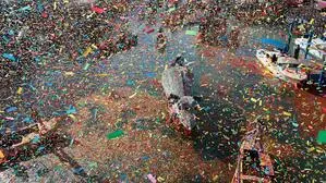 Man sieht geschmückte Boote auf einem Kanal, rundherum fliegt Konfetti durch die Luft | Die Pantegana im Konfettiregen am Canal Grande