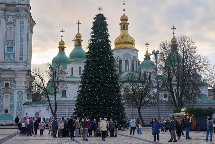 People walk around the Christmas tree in front of St. Sophia Monastery in central Kyiv, Ukraine, Wednesday, Dec. 10, 2025. (AP Photo/Efrem Lukatsky)