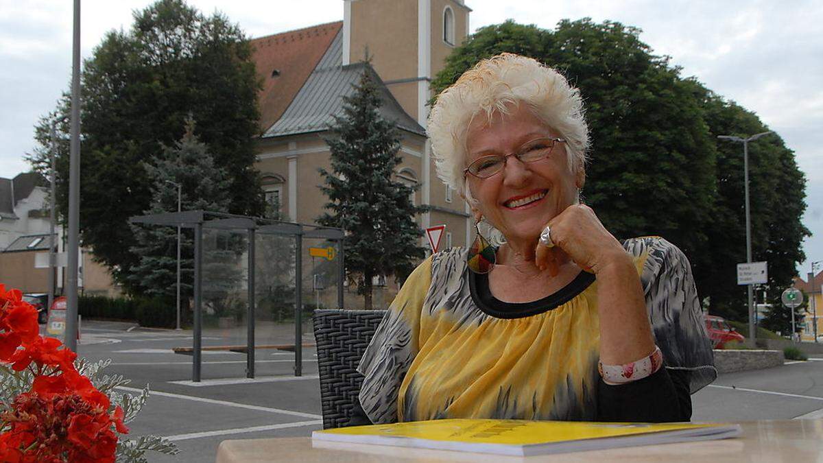 Rosina Christina Moder beim Sommergespräch in Gnas, mit der Pfarrkirche im Hintergrund. Dort spielte sie ab ihrem 15. Lebensjahr auf der Orgel. Ihr Mentor war der kürzlich verstorbene Professor Alois Kaufmann 