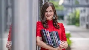 Nicole Stranzl (31), Kleine-Redakteurin und Autorin, hält mehrere ihrer Bücher in der Hand