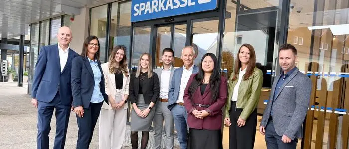 Mitarbeiter stehen vor einer Bank