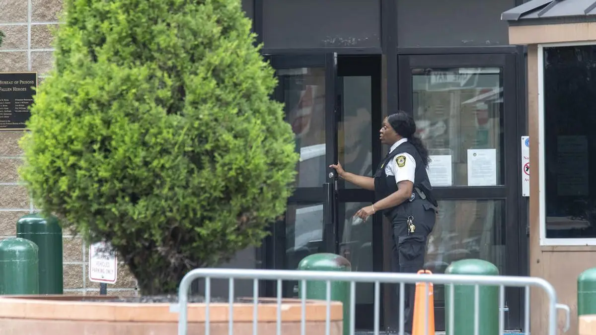 An employee enters the Metropolitan Correctional Center, Tuesday, Aug. 13, 2019 in New York. The warden at the federal jail where Jeffrey Epstein took his own life over the weekend was removed Tuesday and two guards who were supposed to be watching the financier were placed on leave while federal authorities investigate the death. The move by the Justice Department came amid mounting evidence that the chronically understaffed Metropolitan Correctional Center may have bungled its responsibility to keep the 66-year-old Epstein from harming himself while he awaited trial on charges of sexually abusing teenage girls. (AP Photo/Mary Altaffer)
