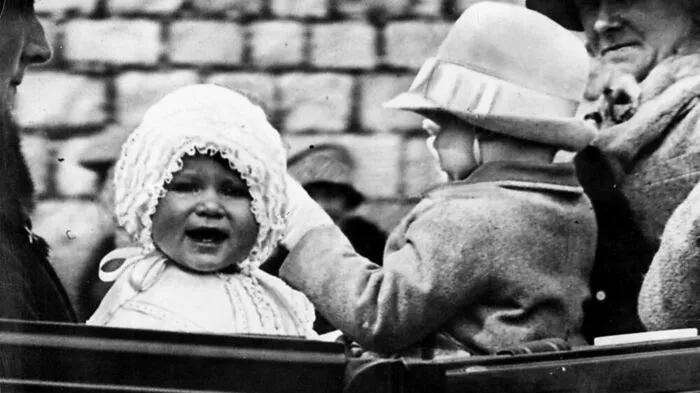 Queen Elizabeth. Sie war 1927 ein Jahr alt. Das Foto zeigt die kleine Prinzessin bei einer ihrer ersten Ausfahrten auf den Grundstücken des Windsor Castles.
