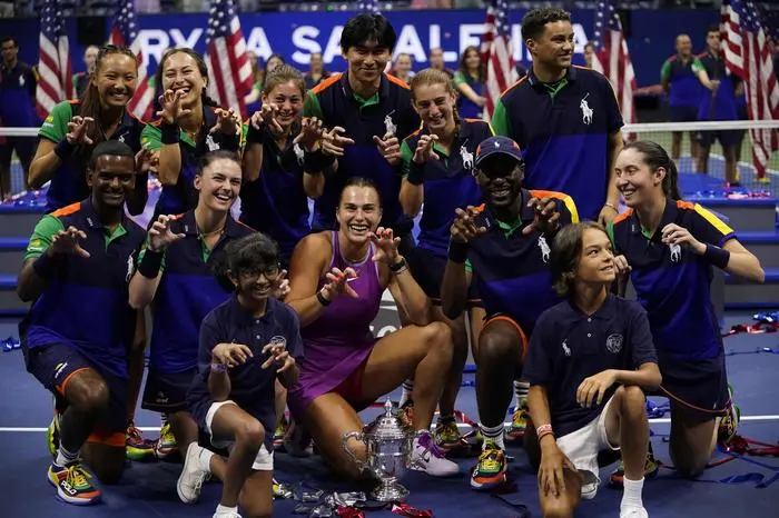 TOPSHOT - Tournament champion Belarus's Aryna Sabalenka poses with the ball crew after the women's final match on day thirteen of the US Open tennis tournament at the USTA Billie Jean King National Tennis Center in New York City, on September 7, 2024. (Photo by TIMOTHY A. CLARY / AFP)