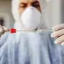 Man in protective suit with mask holding sample buccal cotton swab and test tube ready to collect DNA from the cells. Coronavirus covid-19. Infection prevention and control of epidemic. World pandemic.  World pandemic 