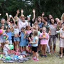 Zahlreiche Kinder und Frauen stehen zusammen und freuen sich 