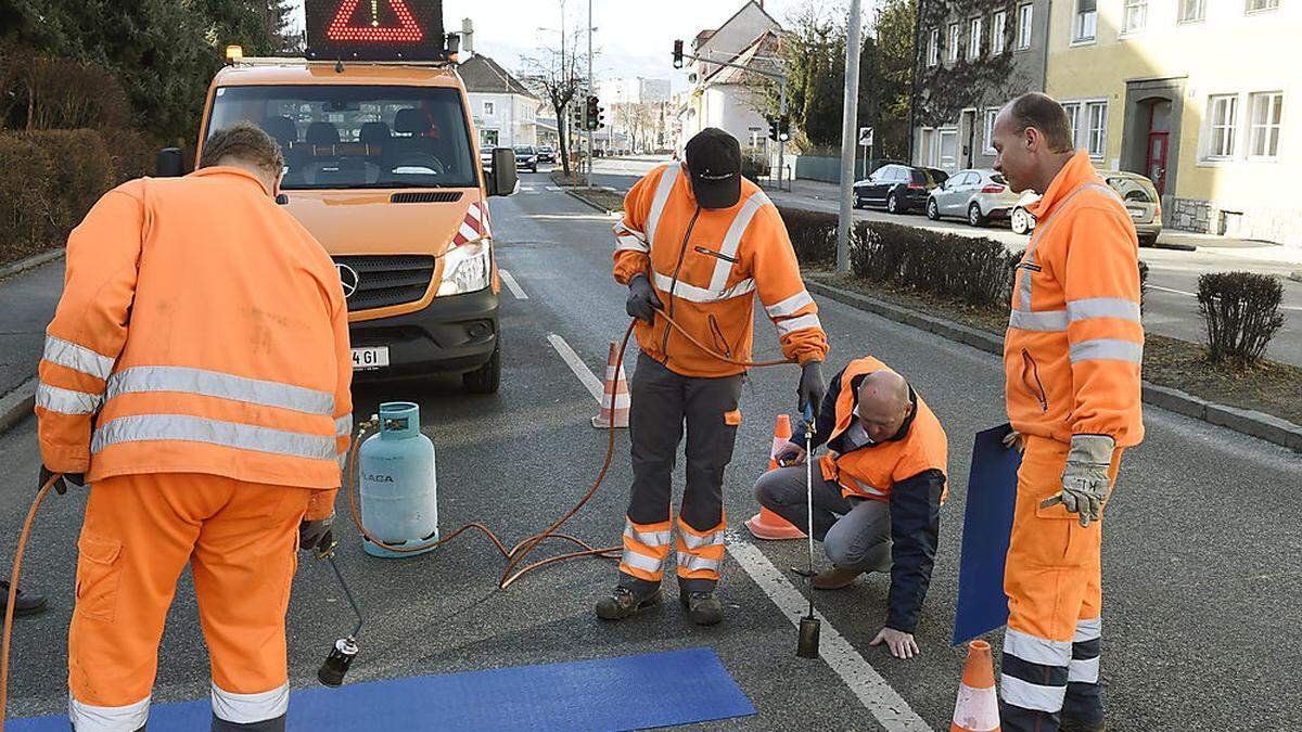 Die Mitarbeiter der Abteilung Straßenbau und Verkehr bringen Zusatzmarkierungen an