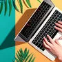 Person using a laptop computer with tropical leaves