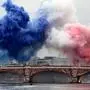 Coloured smoke forms the French flag on the Austerlitz bridge over the river Seine at the start of the opening ceremony of the Paris 2024 Olympic Games in Paris on July 26, 2024. (Photo by Aris MESSINIS / AFP)