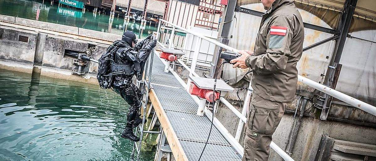 Taucher suchen den Bereich unter  Wasser ab, auch ein Roboter kommt zum Einsatz