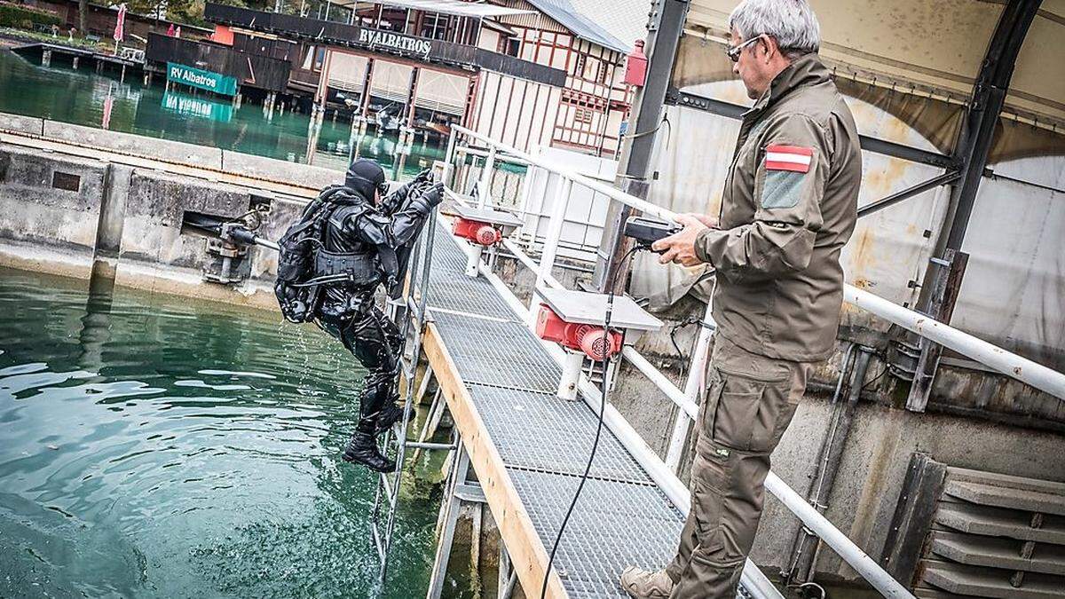 Taucher suchen den Bereich unter  Wasser ab, auch ein Roboter kommt zum Einsatz
