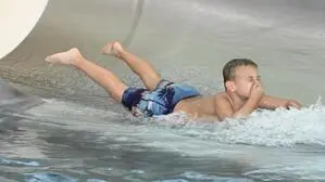 Ein Junge rutscht auf einer Wasserrutsche | In den Weihnachtsferien stehen Familienausflüge in Oberkärntens Thermen am Programm