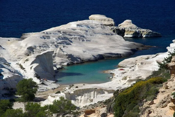 Sarakiniko Beach, Milos.Wie eine Mondlandschaft mutet der Sarakiniko Beach im Norden der ägäischen Insel Milos an. Die weißen Felsen sind vulkanischen Ursprungs und wurden über Jahrhunderte hinweg vom Meer glatt gespült und machen diese Bucht so besonders. Vor dem Blau des Himmels leuchten die Felsen strahlend weiß. Dieser beeindruckende Kontrast ist ein beliebtes Fotomotiv der Urlauber.