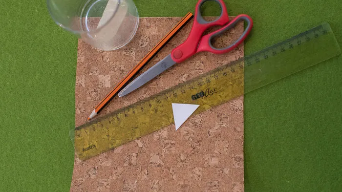 Sie brauchen: ein altes Trink-, Gurken- oder Marmeladeglas, selbstklebendes Korkpapier, Bleistift,Lineal, Schere, Geschirrtuch.