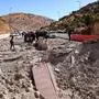 TOPSHOT - People fleeing Israeli bombardment in Lebanon, walk near a crater caused by an Israeli strike, in the area of Masnaa on the Lebanese side of the border crossing with Syria, on October 4, 2024. (Photo by HASSAN JARRAH / AFP)