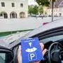Eine Parkuhr mit Auto im Hintergrund