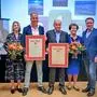 Sechs Personen stehen nebeneinander, die beiden Firmenchefs haben jeweils eine Urkunde in der Hand | Matthias Pirker, Sabine, Karl-Heinz, Karl und Erika Filzmaier mit Ewald Tschabitscher