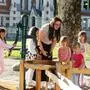 Eine Frau und mehrere Kinder auf einem Spielplatz