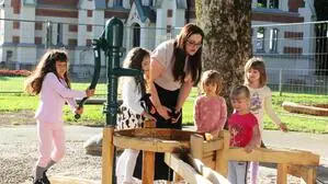Eine Frau und mehrere Kinder auf einem Spielplatz