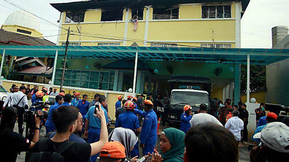 Feuerwehr und andere Hilfskräfte vor der &quot;Darul Quran Ittifaqiyah Religionsschule&quot;,wo das Feuer wütete