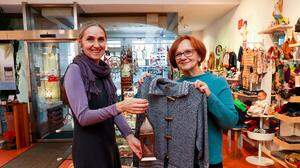 Zwei Frauen, fotografiert im Geschäft, mit einem fair produzierten Kleidungsstück | Weltladen: Mitarbeiterin Irmgard Jöbstl und Geschäftsführerin Elfi Zechner