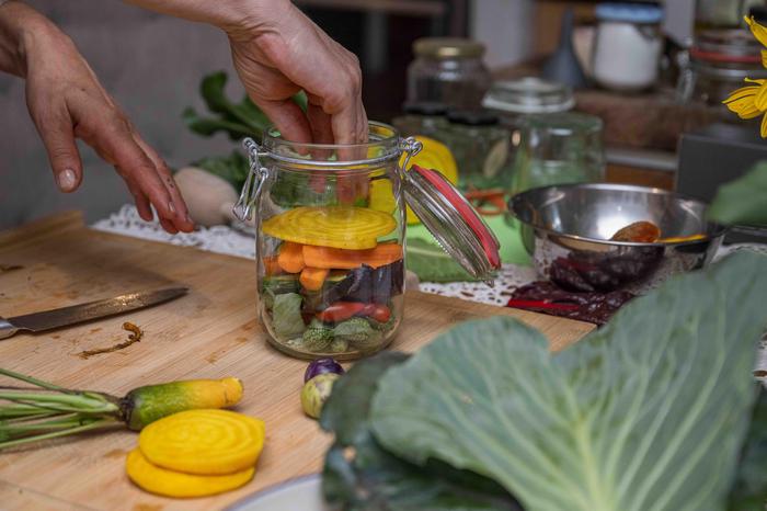 Fermentationsgläser füllt man erst mit Kräutern nach Wahl, dann mit dem jeweiligen Gemüse oder auch einem Gemüsemix und gießt danach alles mit einer Salzlake auf.