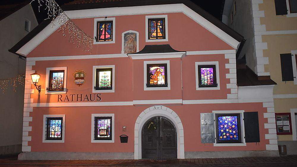Die Fenster des Rathauses in Oberdrauburg leuchten vorweihnachtlich 