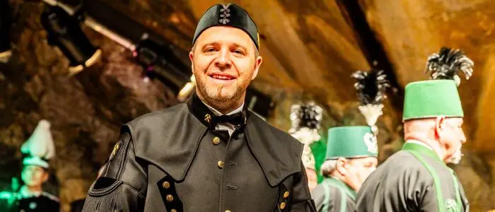 Ein Mann in Bergmannskluft lächelt in die Kamera