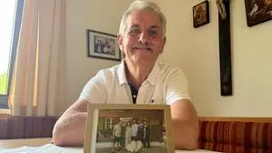 Franz Windisch (66) Zuhause am Küchentisch mit einem Foto seiner sieben Kinder und ihm selbst. Seine Frau ist vor wenigen Jahren verstorben