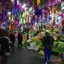 FILE - Christmas piñatas for sale hang over a fruit vendor's stall at the Jamaica market in Mexico City, Dec. 14, 2023. (AP Photo/Fernando Llano, File)