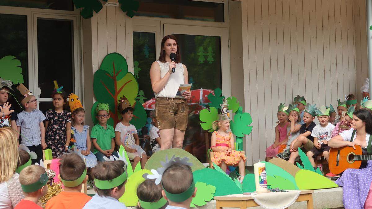 Kindergartenleiterin Nicole Kornthaler freut sich mit den Kindern über das sanierte Gebäude