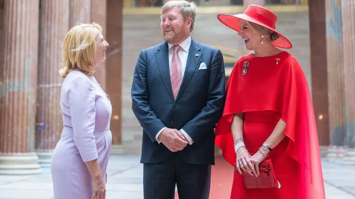 Am ersten Tag trug Máxima ein karminrotes Kleid mit Cape und breitkrempigem Hut.