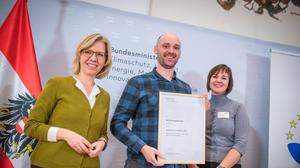Umweltministerin Leonore Gewessler überreicht Michael Zotter und Christa Bierbaum die Urkunde bei einer Feier in Wien