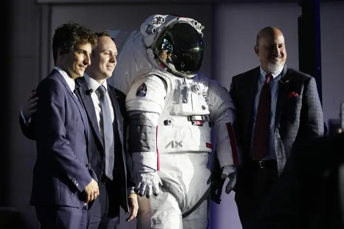 Axiom Space President Matt Ondler, right, Prada Group Chief Marketing Officer Lorenzo Bertelli, left, and Axiom Executive Vice President Russell Ralstom pose next to their Axiom and Prada-designed spacesuit that will be used by NASA from 2026, in Milan, Italy, Wednesday, Oct. 16, 2024. (AP Photo/Antonio Calanni)